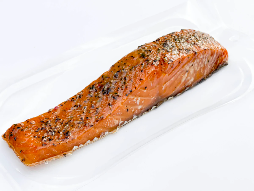 A photo of a strip of hot smoked salmon on a white background