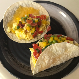 A top down photo of tacos stuffed with scrambled eggs and salsa cruda
