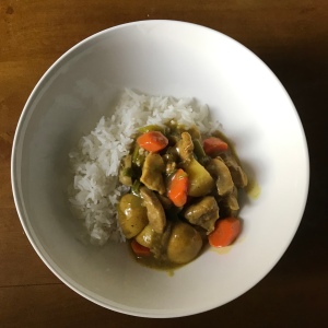A top down photo of curry rice in a white bowl