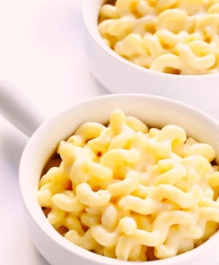 A photo of 2 white bowls filled with cheesy pasta 