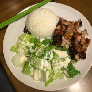 A photo of teriyaki, rice and salad on a white plate. 