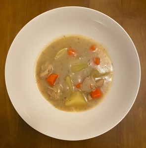 A photo of chicken stew in a white bowl. 
