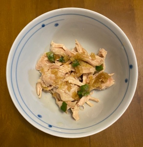 A small bowl with a portion of chicken with ginger sauce