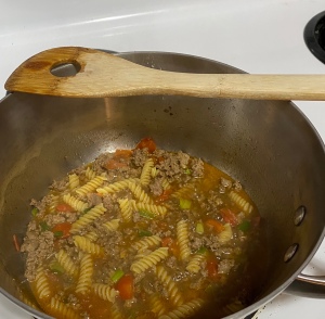 A pot of chili-mac cooking on the stove