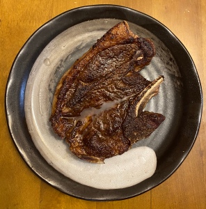 A seared lamb chop on a plate