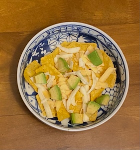 Tortilla chips, shredded cheese and avocado form the ‘nachos’ base. 