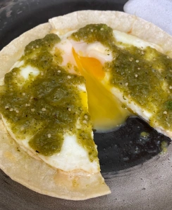 Salsa verde over fried eggs on a plate